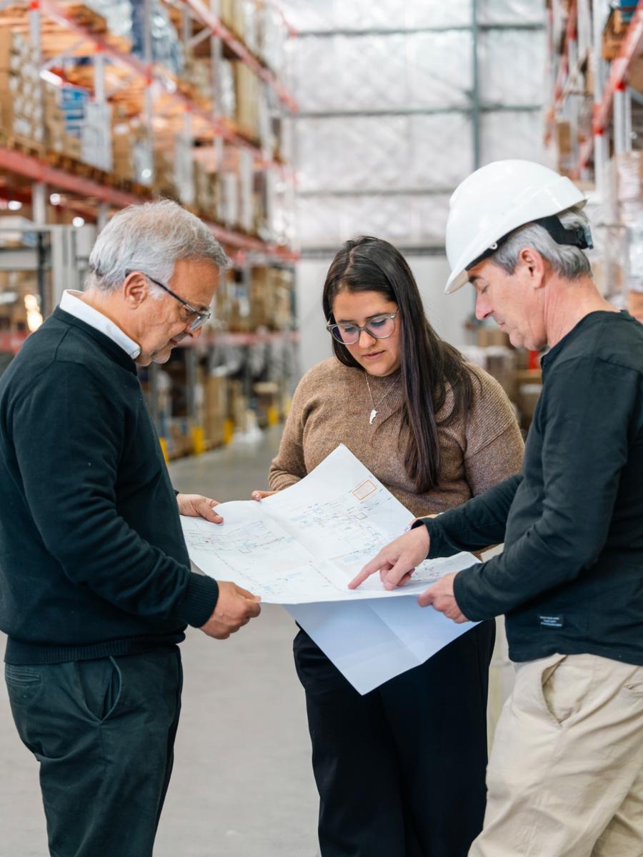 Equipo de DEPRO revisando un plano en un depósito logístico