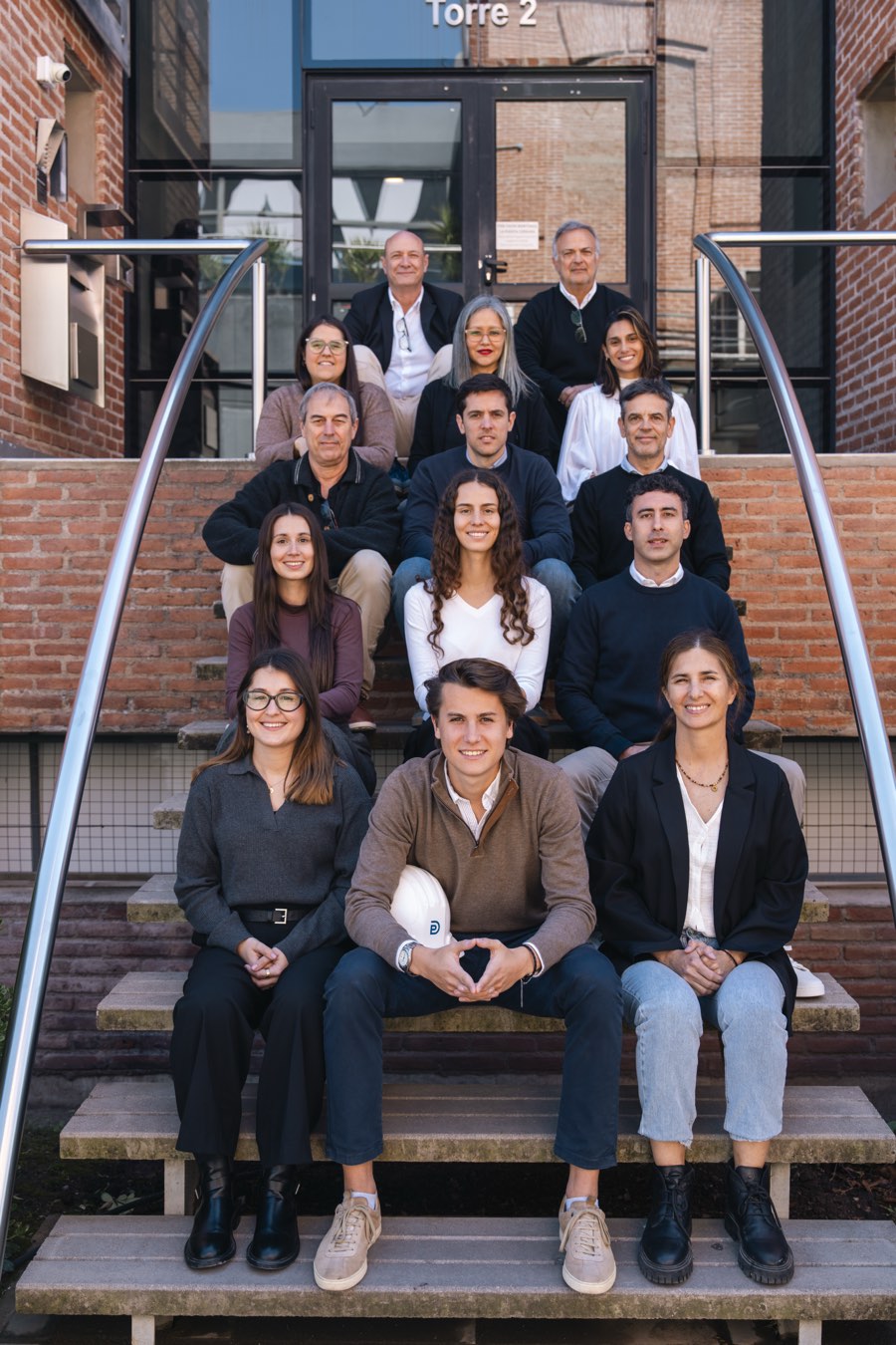Equipo completo de Depro reunido en las escaleras de la oficina