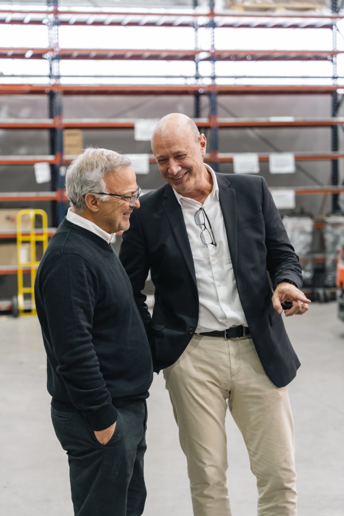 Dos integrantes del equipo Depro conversando en un depósito